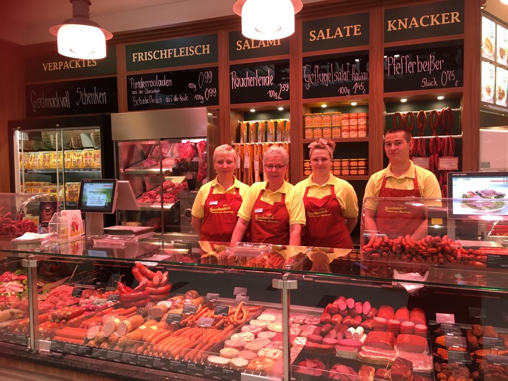 Filiale NeißePark Görlitz Vier Mitarbeiter hinter der Frischetheke mit dem großen Fleisch- und Wurstangebot